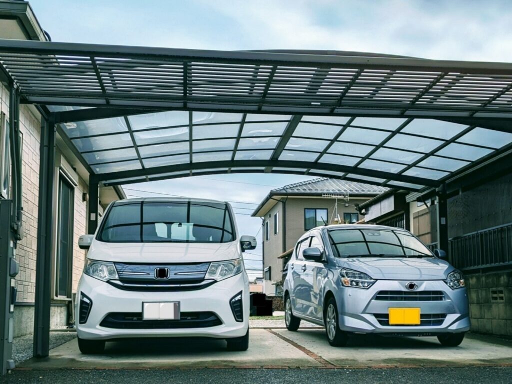 駐車場、カーポートに2台の自家用車が停まっている