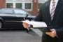Professional,Man,Standing,In,Front,Of,Black,Car,Holding,Clipboard
